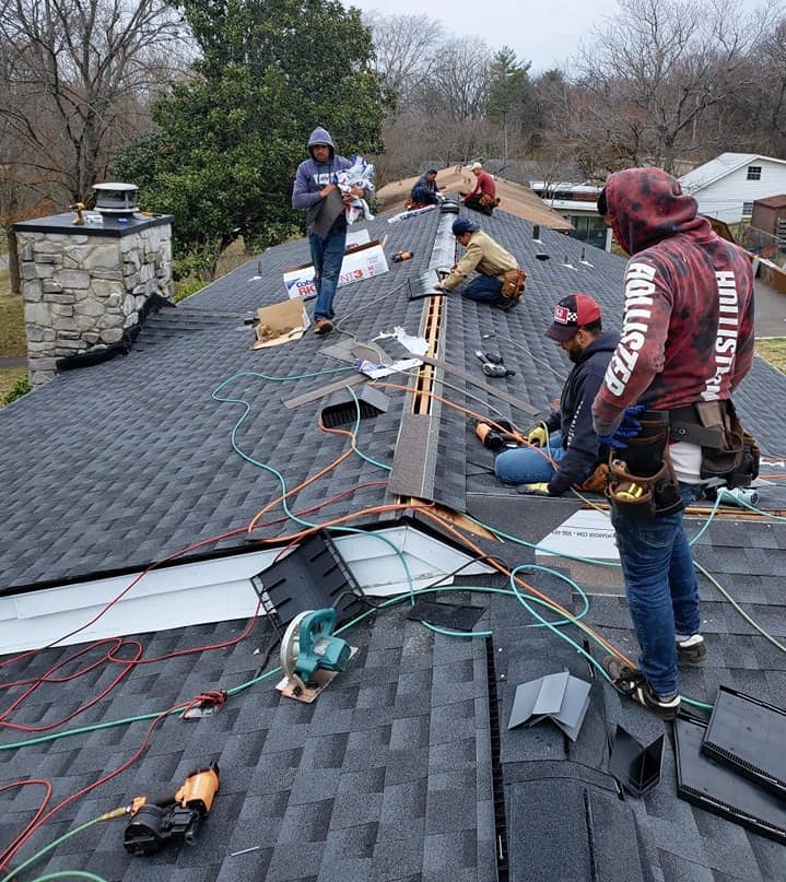 CCC Roofing employees working on a gray asphalt rooftop